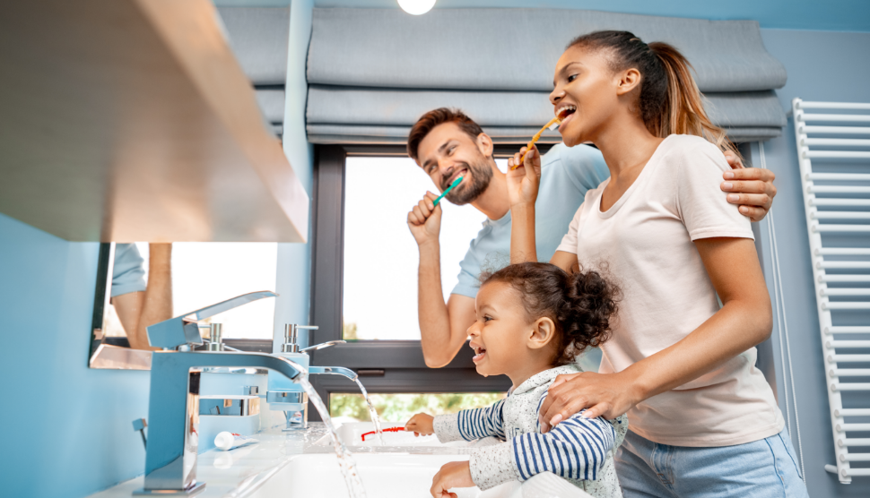 Family brushing their teeth over the sink