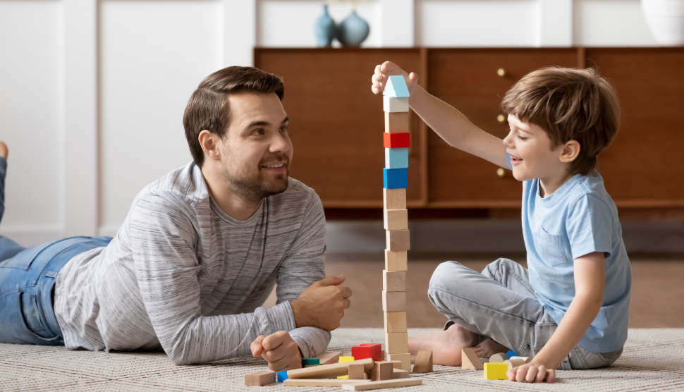 father and son playing with blocks on floor